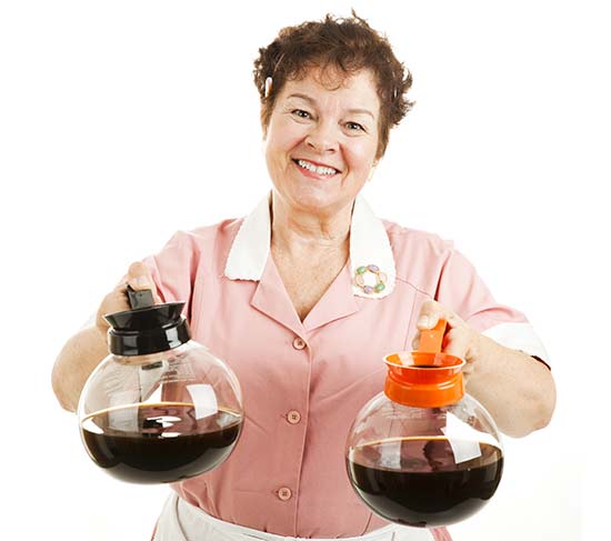 Le sens du mot breuvage en québécois. Une serveuse souriante présente du café à ses clients.